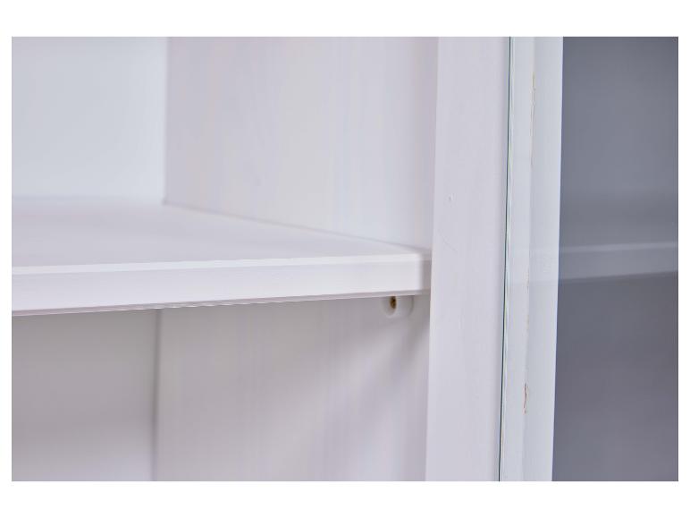 Witte kast met planken en glazen deur.