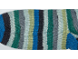 Close-up van een veelkleurige gestreepte gebreide sok in blauw, groen, grijs en wit.