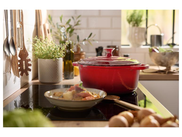 Rode gietijzeren pan op een inductiekookplaat.