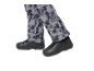 Grijze bedrukte broek en zwarte schoenen.