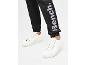 Zwarte joggingbroek met Bench-logo en witte sneakers.