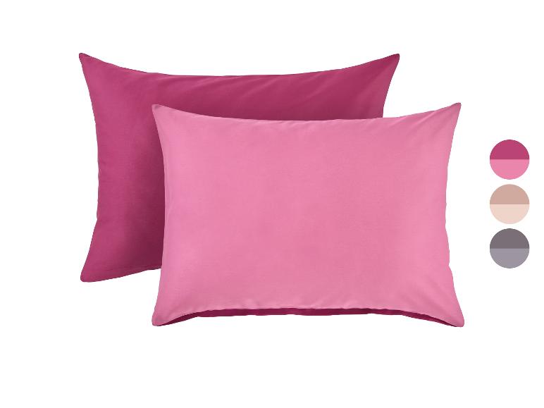 Twee roze kussens, één donkerroze en één lichtroze, met kleurstalen ernaast.