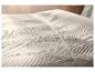 Gecapitonneerde LIVARNO home sprei met golfpatroon op een bed.
