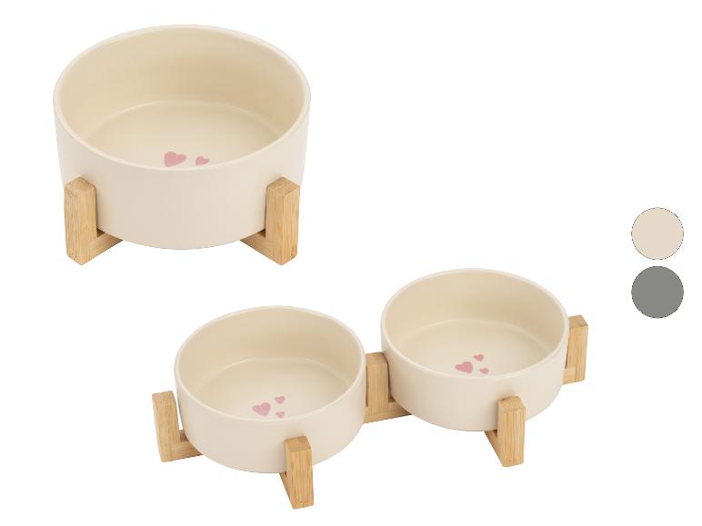 Beige voerbakken voor huisdieren met houten standaards, versierd met roze hartjes.