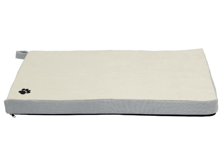 Een beige hondenbed met een grijze rand.