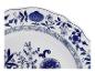 Wit bord met blauw bloemmotief en golvende rand.