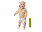 Baby in een beige vestje met konijnenborduurwerk en gestreepte broek.