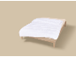 Eenpersoonsbed met wit dekbed en beige hoeslaken op een neutrale achtergrond.