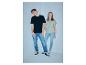 Twee jonge mensen in casual T-shirts en jeans, staand in een hoek.