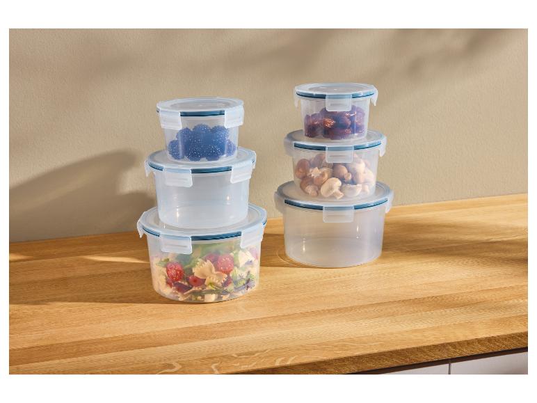 Transparante stapelbare voedselcontainers met bessen, dadels, champignons en salade.