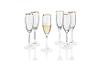 Een set champagne glazen met een gouden rand, waarvan één gevuld is.