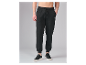 Zwarte joggingbroek voor heren met trekkoord en zwarte sneakers.