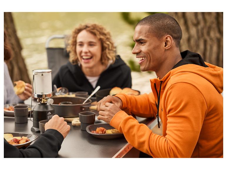 Buiten koken met een Primus lamp en oranje kleding.