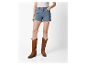 Vrouw in jeans shorts en bruine cowboylaarzen.