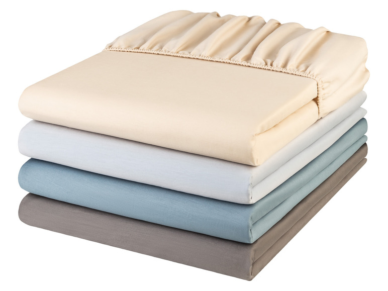 Een stapel van vier beige, witte, blauwe en grijze hoeslakens.