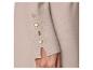 Beige truimouw met gouden knopen en gespleten manchet.