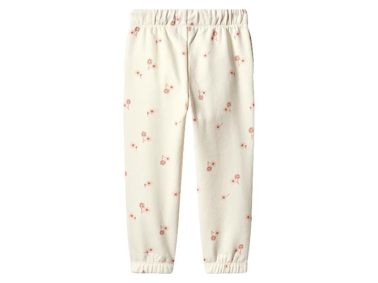 Crèmekleurige kinder joggingbroek met een delicaat bloemenpatroon.