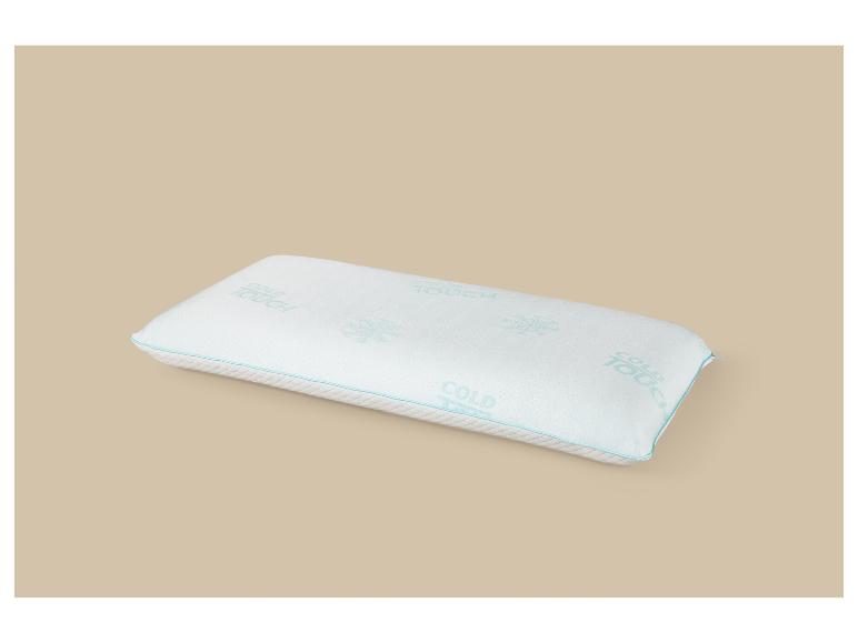 Wit kussen met de tekst „COLD TOUCH” en blauwe bies op een beige achtergrond.