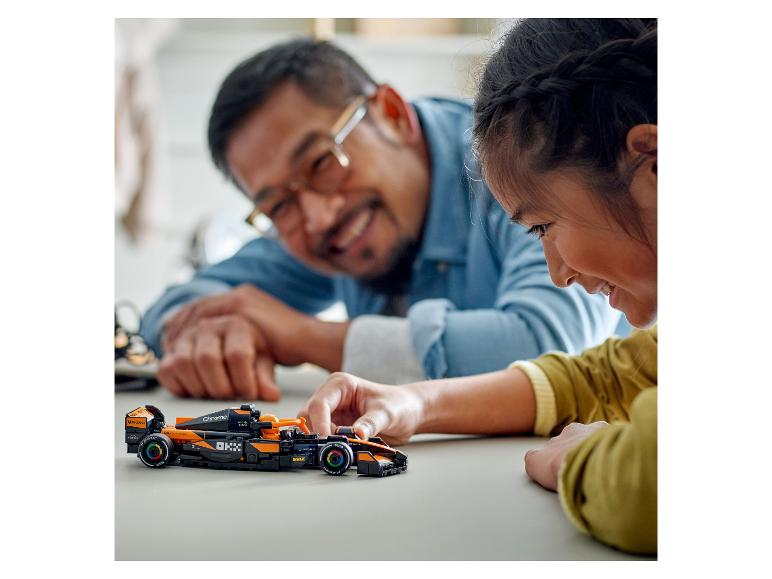 Een kind speelt met een LEGO McLaren Formule 1 raceauto.