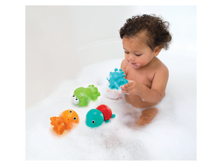 Baby speelt met badspeelgoed: kikker, schildpad en octopus.