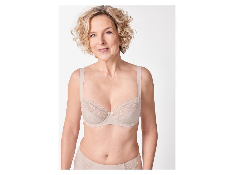 Vrouw toont lichtbeige bh en slip.