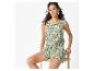Vrouw in een groene playsuit met bladprint, zittend op een kruk.