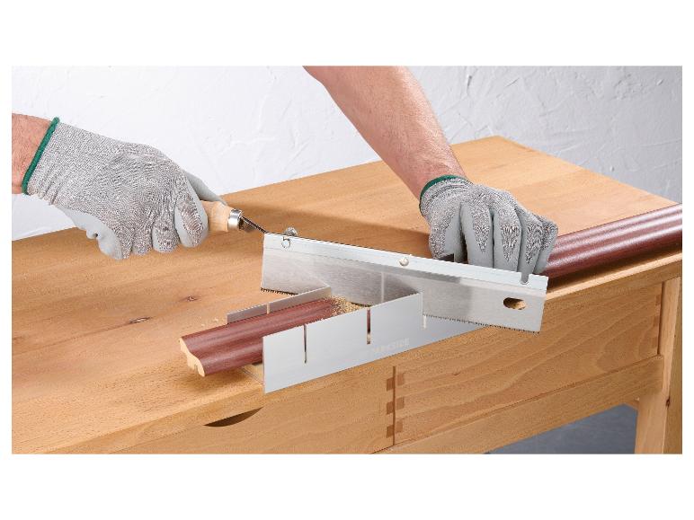 Een persoon zaagt een houten lat met een handzaag in een Parkside zaagbok.