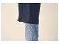 Donkerblauwe regenjas over lichtblauwe jeans.