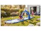 Kinderen spelen op een opblaasbare waterspeelmat met haaienboog in een zonnige tuin.