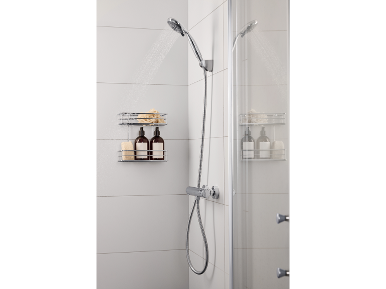 Moderne douche met stromend water, een doucheplank met twee flessen en sponzen.