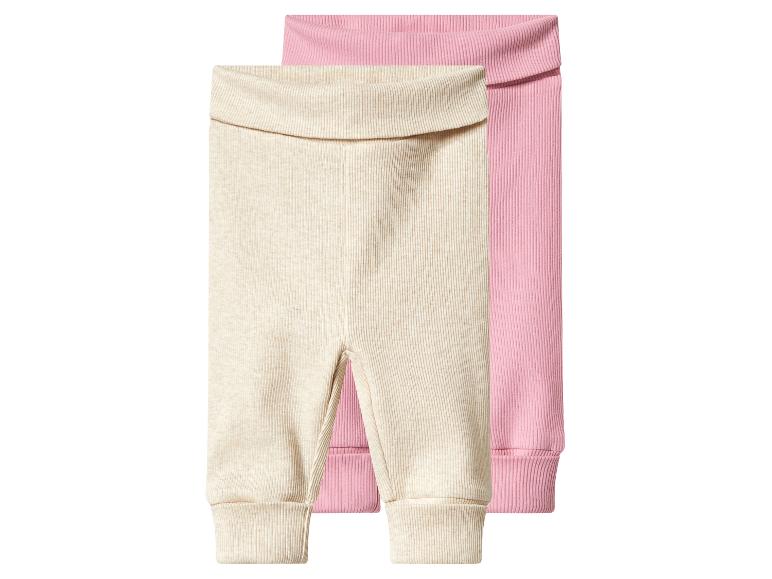 Twee geribbelde baby leggings, één beige en één roze.
