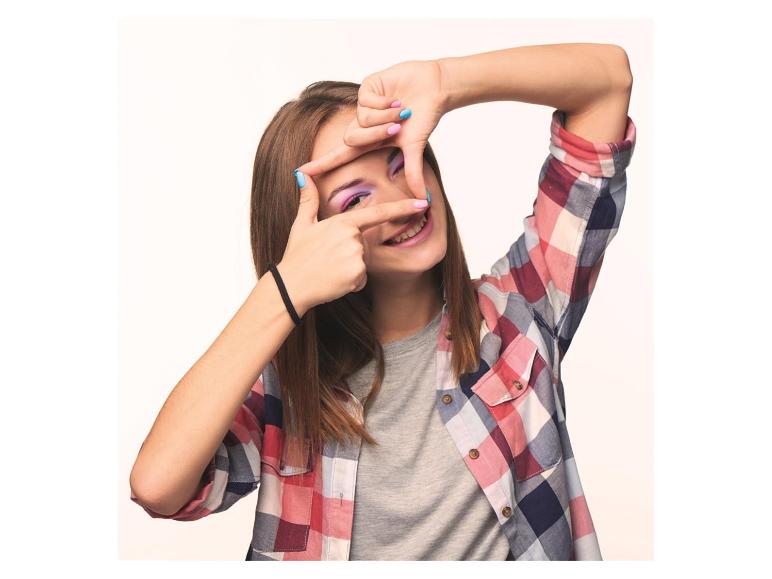 Lachende vrouw in geruit overhemd, die met haar handen een kader rond haar oog vormt.
