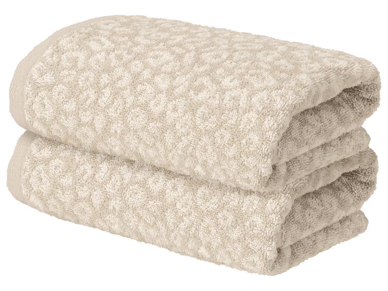 Twee gevouwen beige handdoeken met patroon