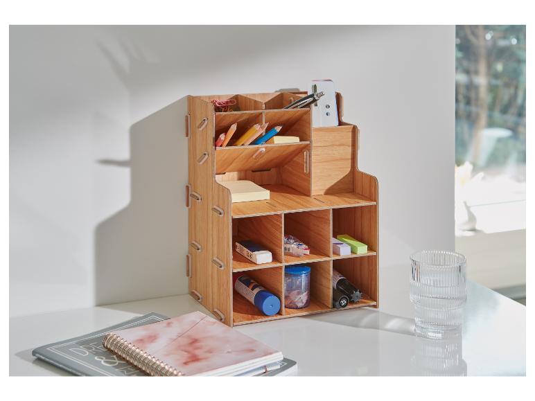 Een houten bureau-organizer met compartimenten voor pennen, potloden, gummen en andere kantoorartikelen.
