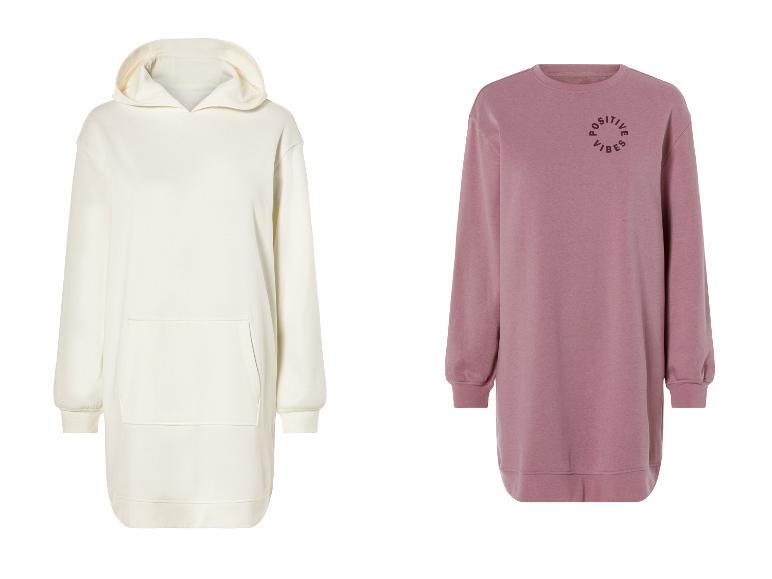 Twee lange sweaters: een witte met capuchon en een roze met de tekst 'Positive Vibes'.