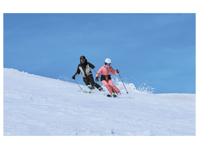 Twee skiërs dalen een besneeuwde helling af.