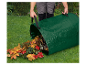 Een man leegt een tuinzack vol met herfstbladeren.