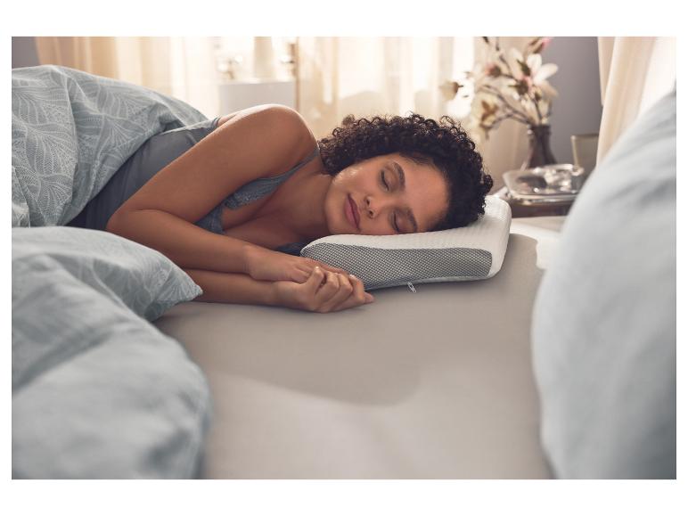 Vrouw slaapt op een ergonomisch multifunctioneel kussen van LIVARNO.