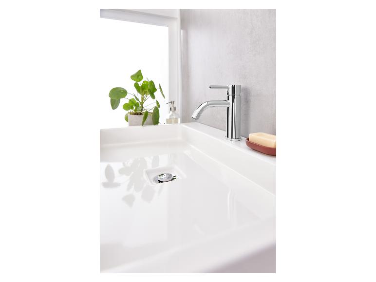 Een witte wastafel met een chromen kraan en een zeepbakje.