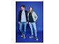 Twee jonge mensen dragen T-shirts en vesten met rits, jeans en sneakers op een blauwe achtergrond.