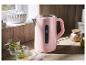 Roze waterkoker op een houten aanrecht met twee glazen thee.