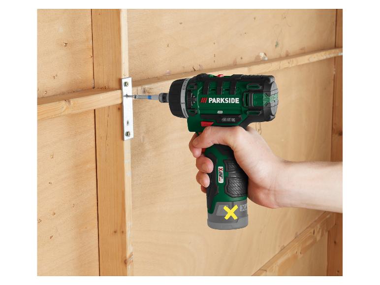 Een man gebruikt een Parkside accu-boormachine om hout te bevestigen.