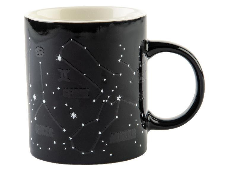 Een zwarte mok met sterrenbeelden, waaronder Gemini.