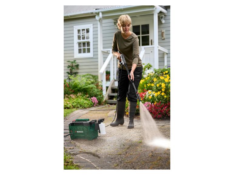 Vrouw reinigt oprit met een Parkside hogedrukreiniger.