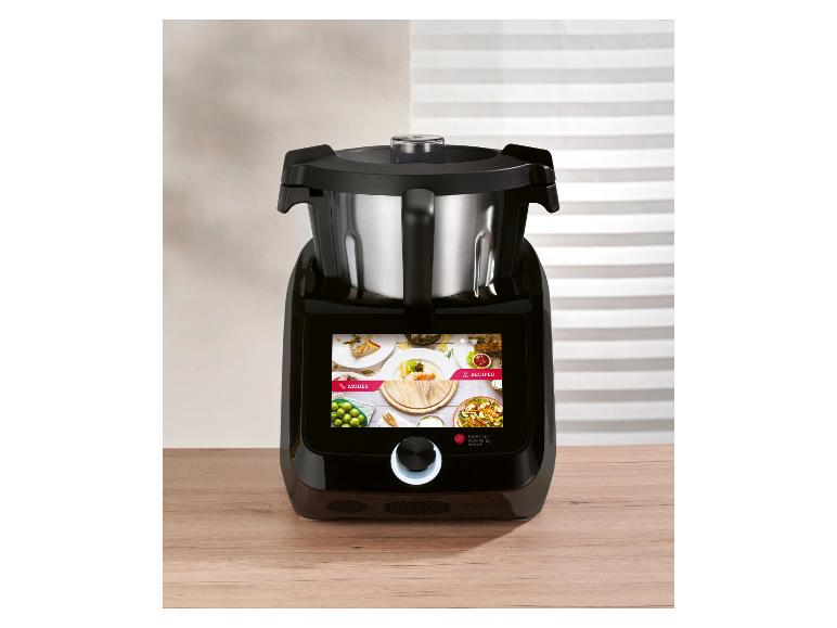 Zwarte keukenmachine met roestvrijstalen kom en touchscreen op een houten aanrecht.