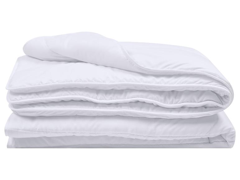 Wit gevouwen dekbed met gestikte randen, geïsoleerd op een witte achtergrond