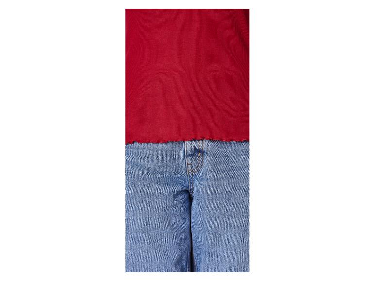 Rode geribbelde top en blauwe jeans