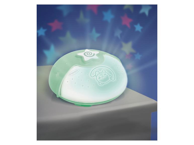 Groene nachtlamp projector met kleurrijke sterren geprojecteerd op een blauwe muur.