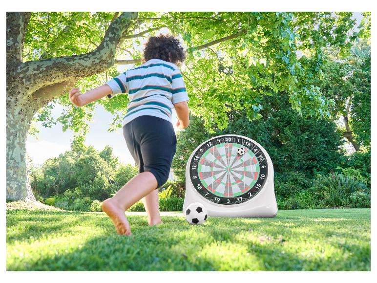 Kind speelt voetbal-darts in de tuin.