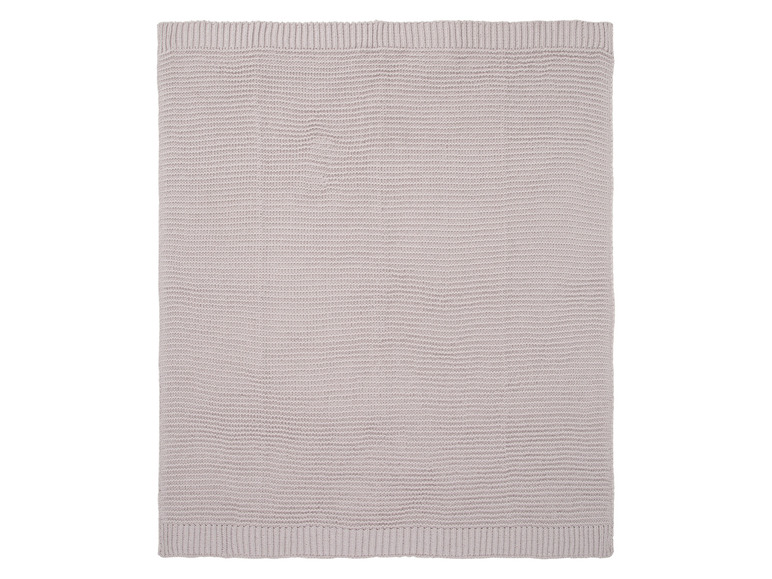 Een lichtgrijs gebreid dekbed